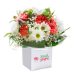 Like a welcome burst of Kidbrooke springtime, this cheerful bouquet is expertly gathered and presented upright in a crisp white gift bag, inviting a smile at first glance. Fluffy coral and peach carnations bloom with frilly opulence, radiating cozy warmth that recalls the vibrant flowerbeds lining Cator Park. Pops of rich red add depth and flair, while snowy white daisies beam with lemon-lime centers, their freshness catching the light and enlivening the scene. Wisps of delicate baby's breath fan through, softening the structure and evoking the gentle drift of petals on a breezy Kidbrooke afternoon. Encircling everything, sleek, robust leaves form a verdant cradle, their glossy sheen echoing the abundant greenery throughout the neighbourhood's gardens and parks. Tucked shyly to one side, tight purple-tinted buds hint at days yet to bloom. The gift bag's double white ribbon handles blend function with grace-ideal for convenient delivery anywhere in SE3. Each component has been placed with intentional artistry, resulting in a bouquet that feels fresh and vibrant, whether as a birthday surprise, thank you, or thoughtful gesture from someone who treasures the unique community spirit of Kidbrooke.